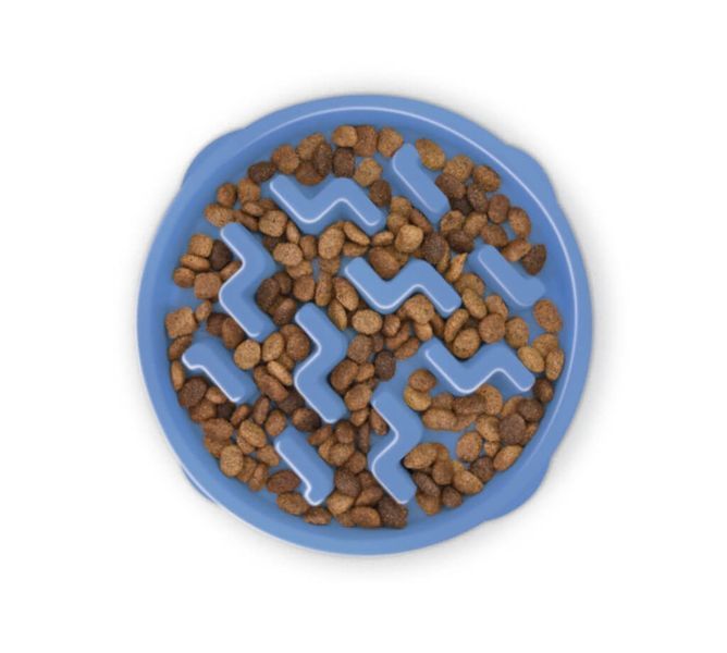 Синя миска-лабіринт Outward Hound Fun Feeder Slo Bowl "Тетріс" розміру M з сухим кормом всередині, що демонструє принцип роботи.